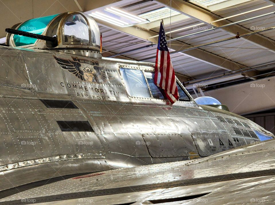 A closeup of the top turret and cockpit area of a 1945 Boeing B-17G that is resting in its hangar