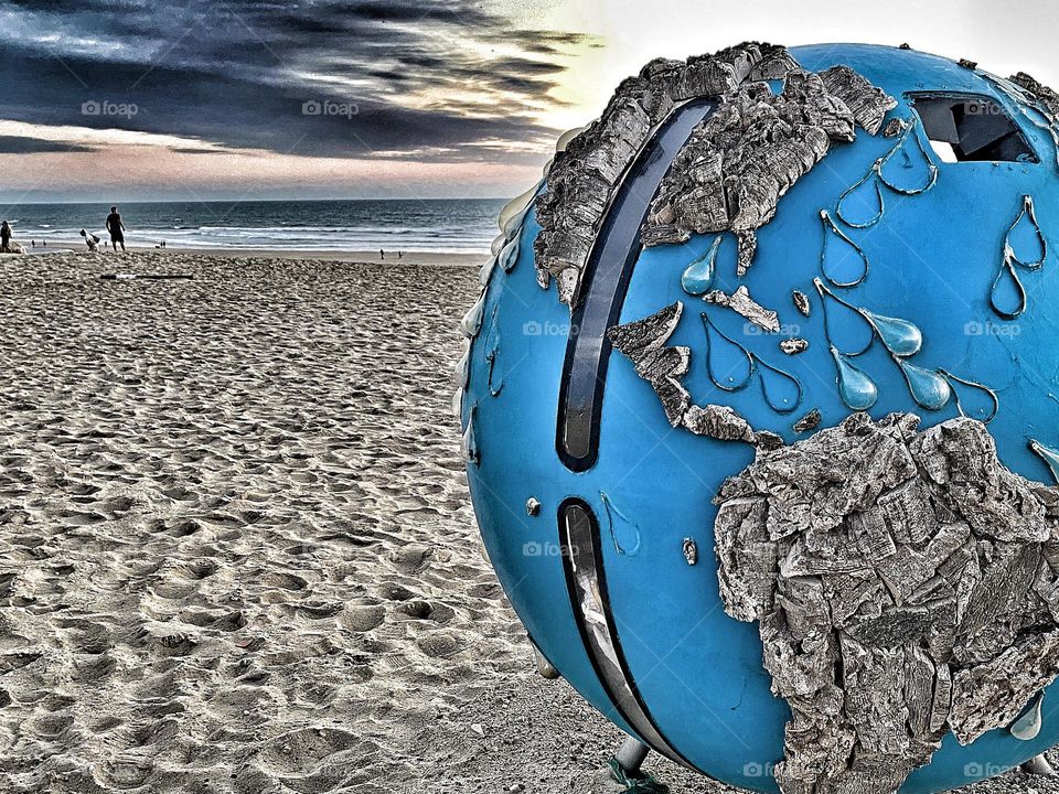 Garbage can globe on the beach.  French Atlantic at sunset.