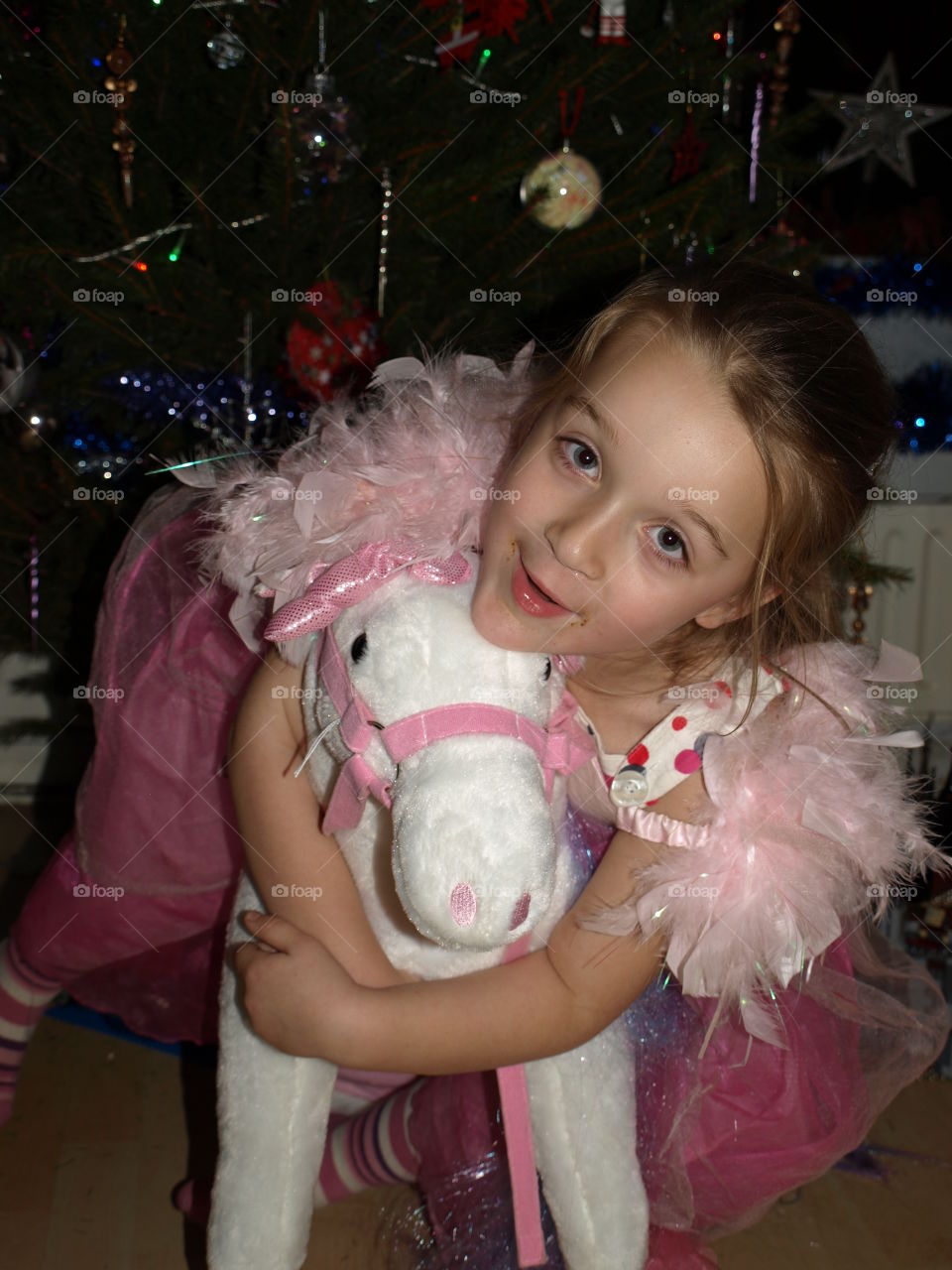 little girl holding a unicorn toy.