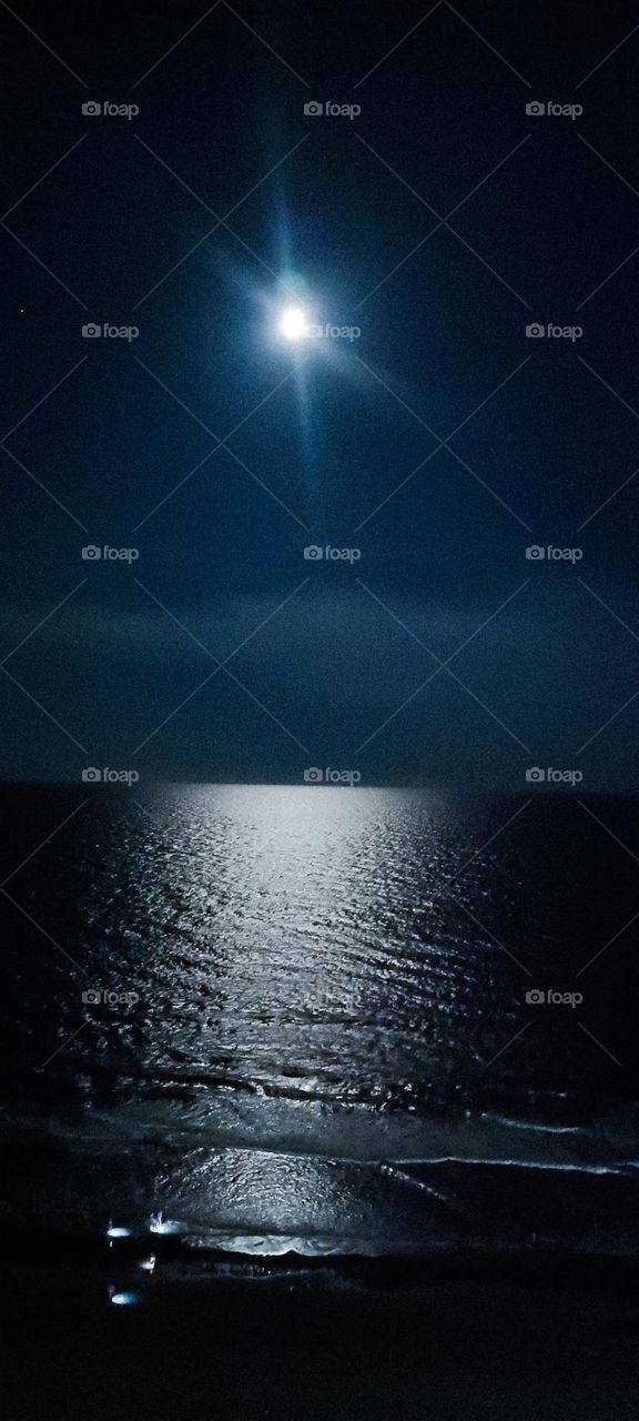 Clear sky with the light of the moon reflecting off of the ocean 