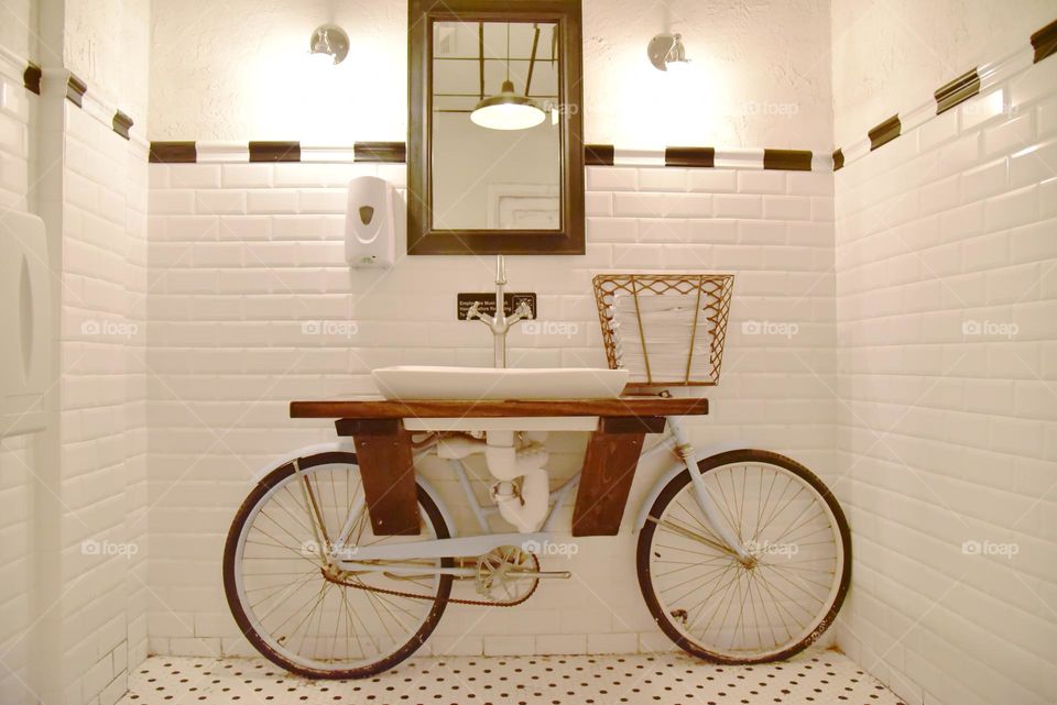 Solitary bicycle, architectural element part of the sink in the washroom