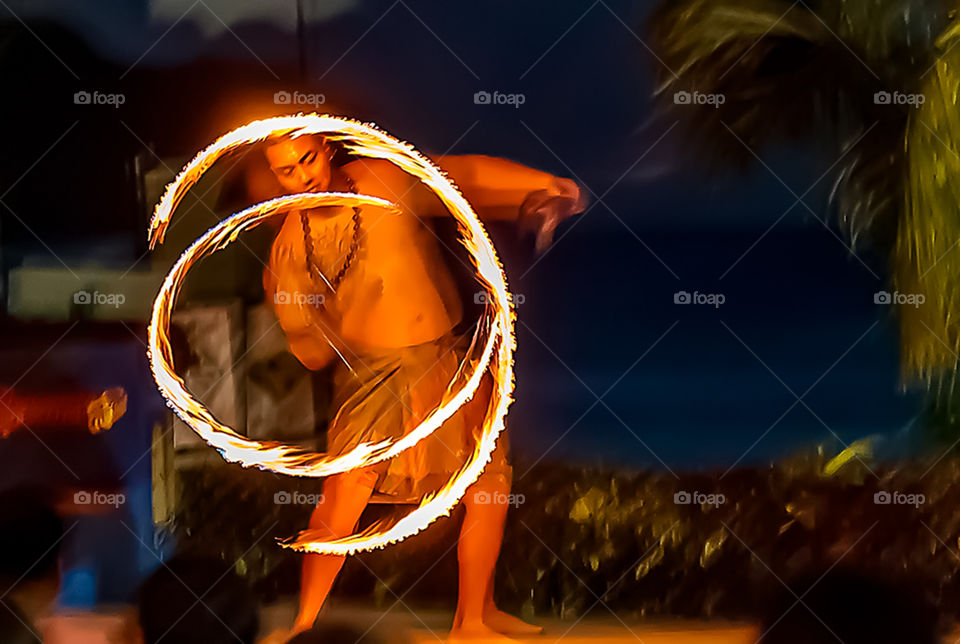 Pacific islands fire twirling performer.