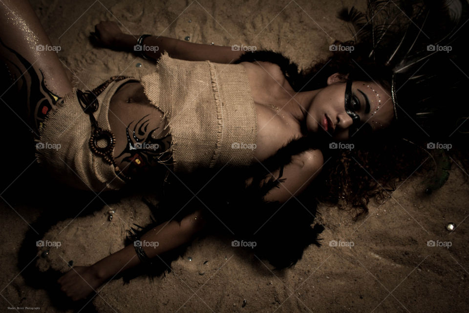 Red Indian lying on sand