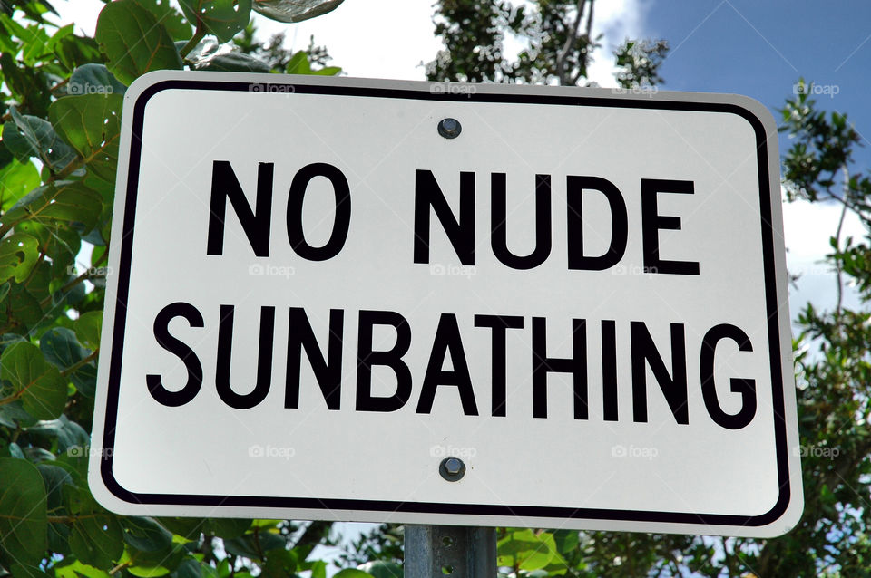 No nude sunbathing sign at the beach. 