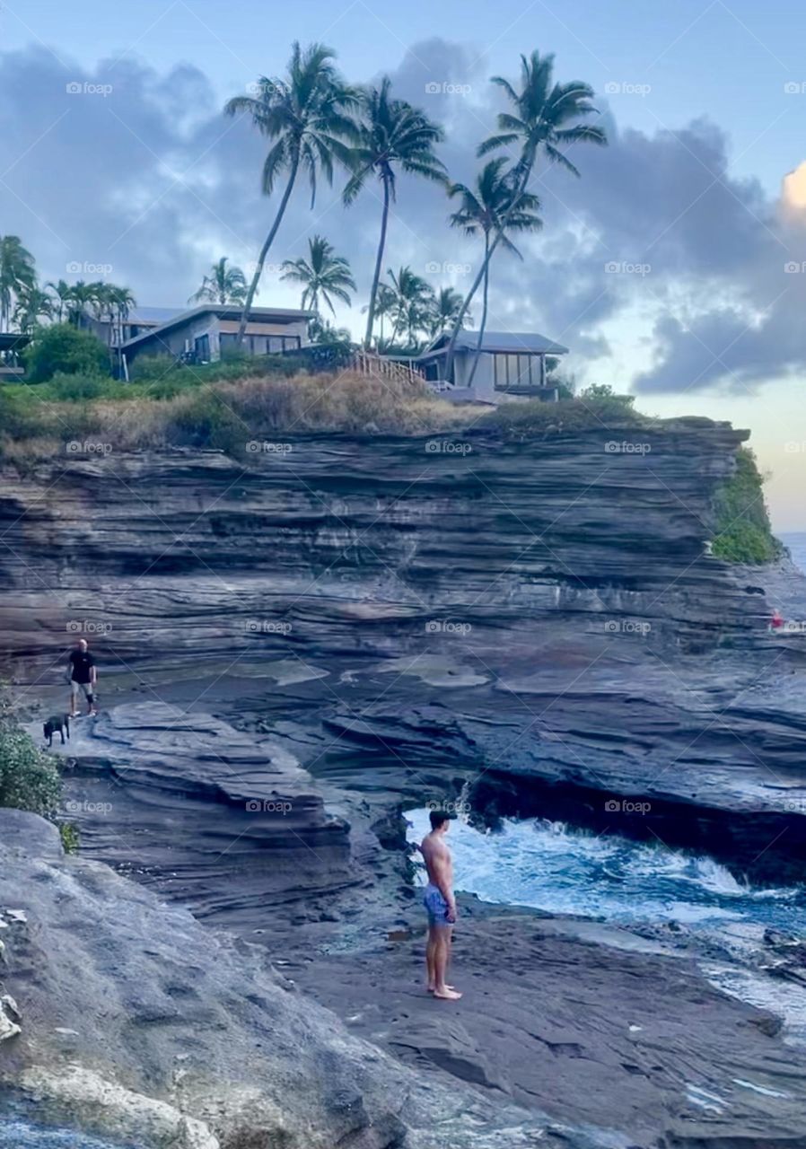Young man rock climbing Hawaii