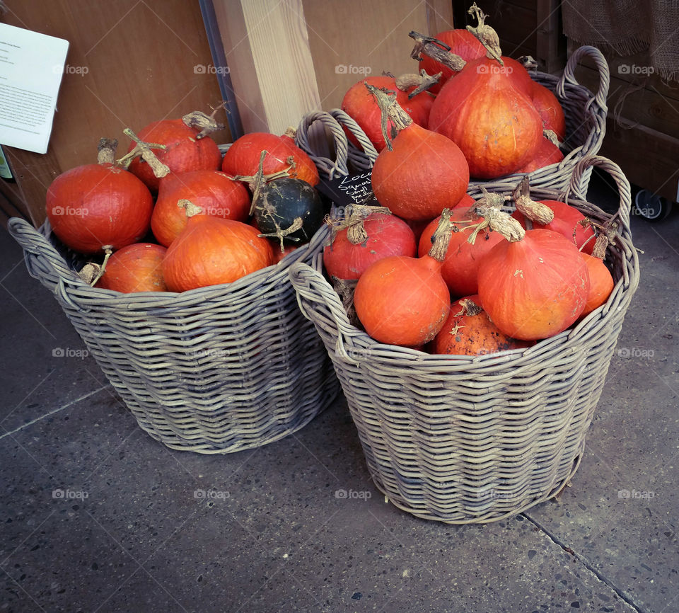 Three baskets of pumpkins in a shop