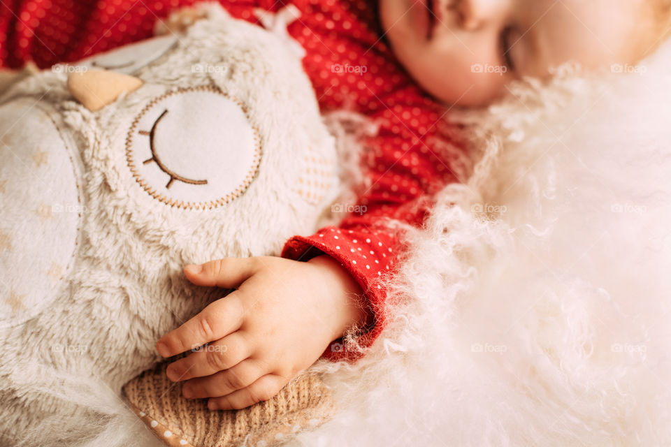 Sleeping baby with hand on front view and owl