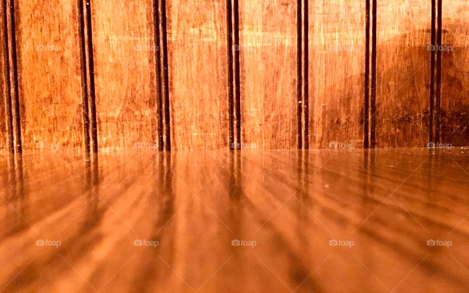 Wood paneling reflects in polished table top