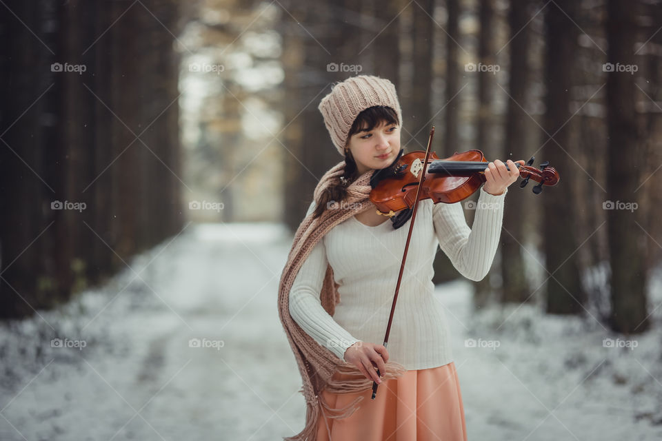 Teenage girl portrait with violin in winter park