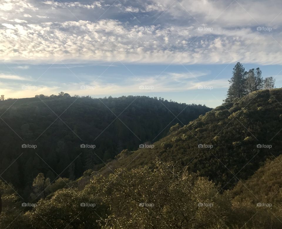 Road trip - rolling green hills on the mountainside and blue sky 