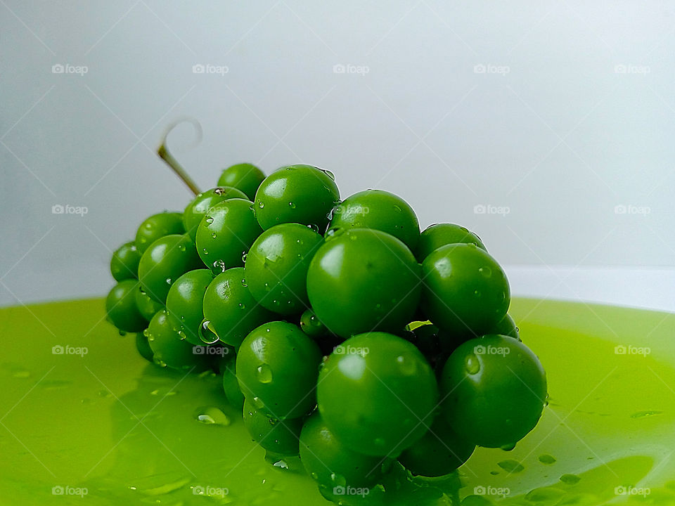 green grapes close-up on a green dish