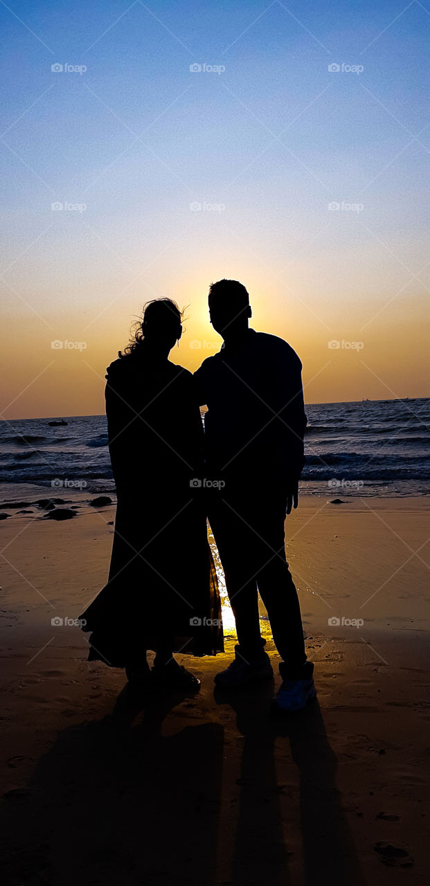 Romantic love couple wallpaper - A couple standing on seashore beach at sunset time. it is silhouette image .
