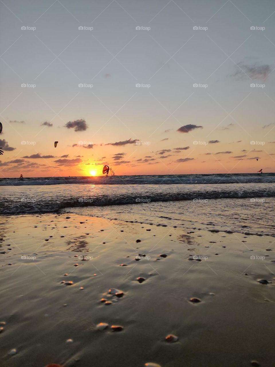 Sunset on northen Sedot Yam, Israel. People practicing paragliders.