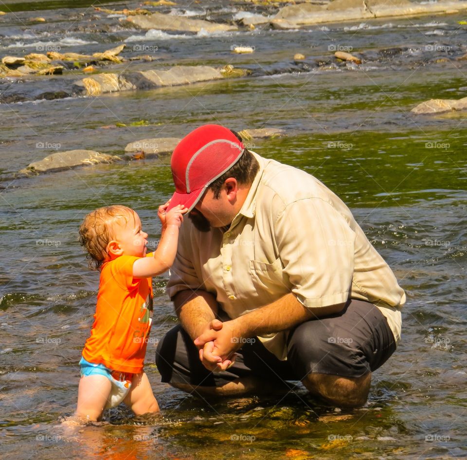 Father and daughter playing in river