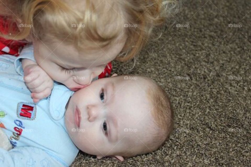 Cute girl kissing her brother on his cheek