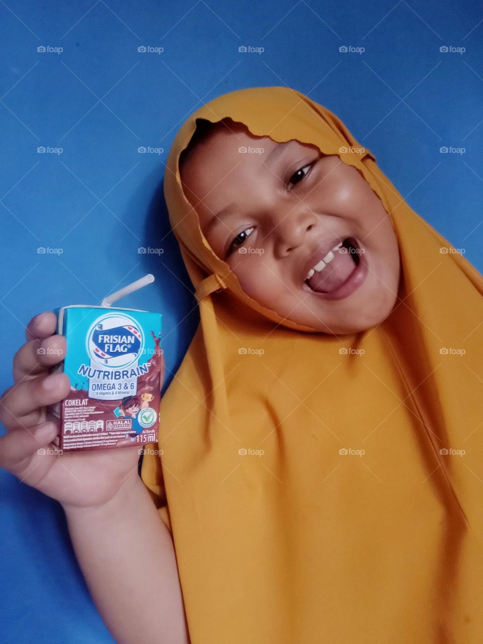 A little girl really likes chocolate milk.