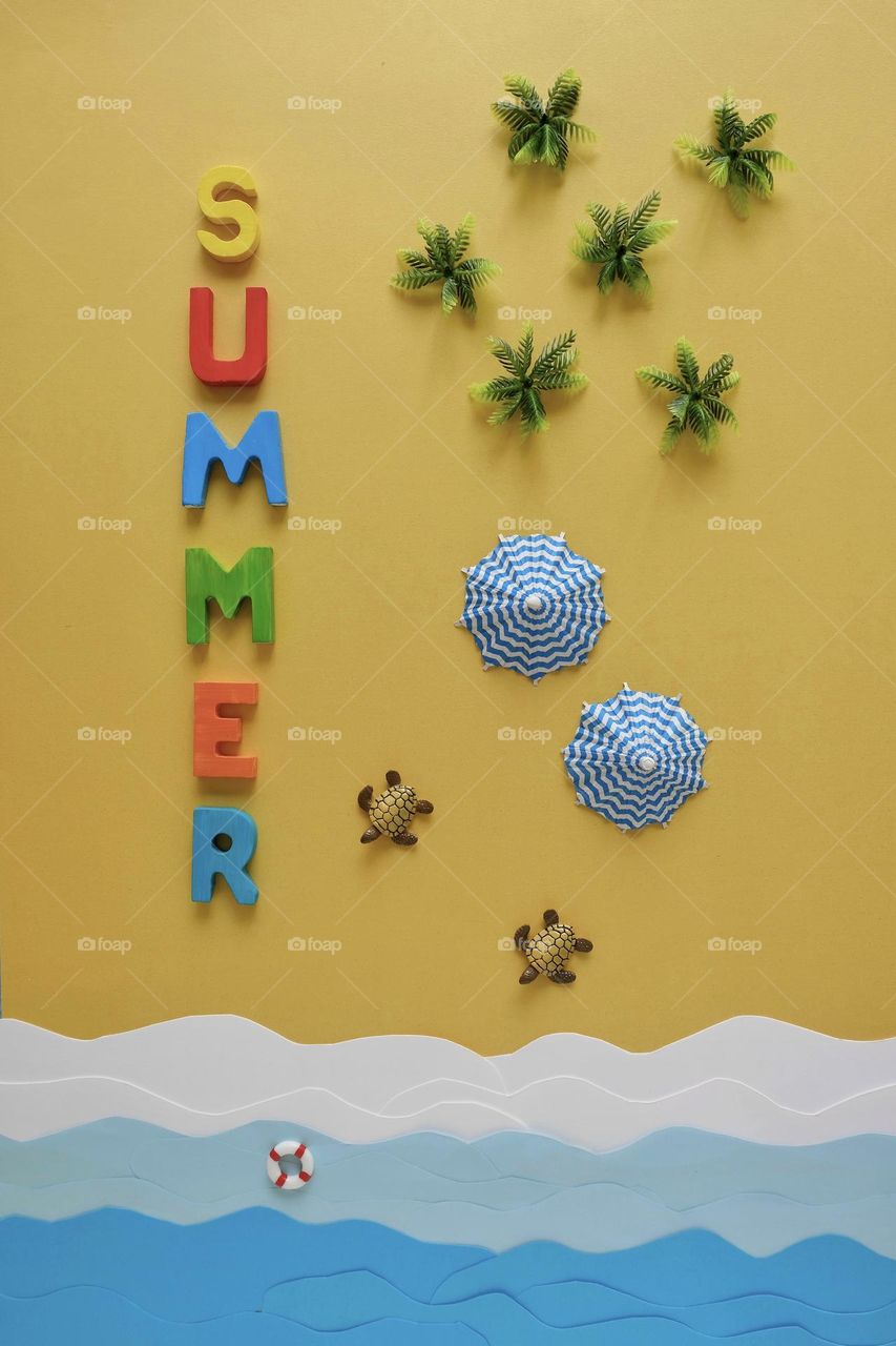 Directly above view of summer arrangement on yellow colored background. 