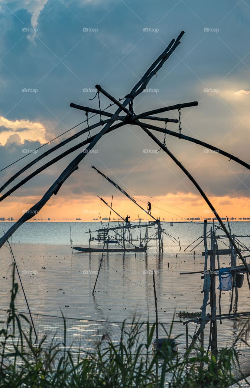 Silhouette of fisherman on their big fish trap