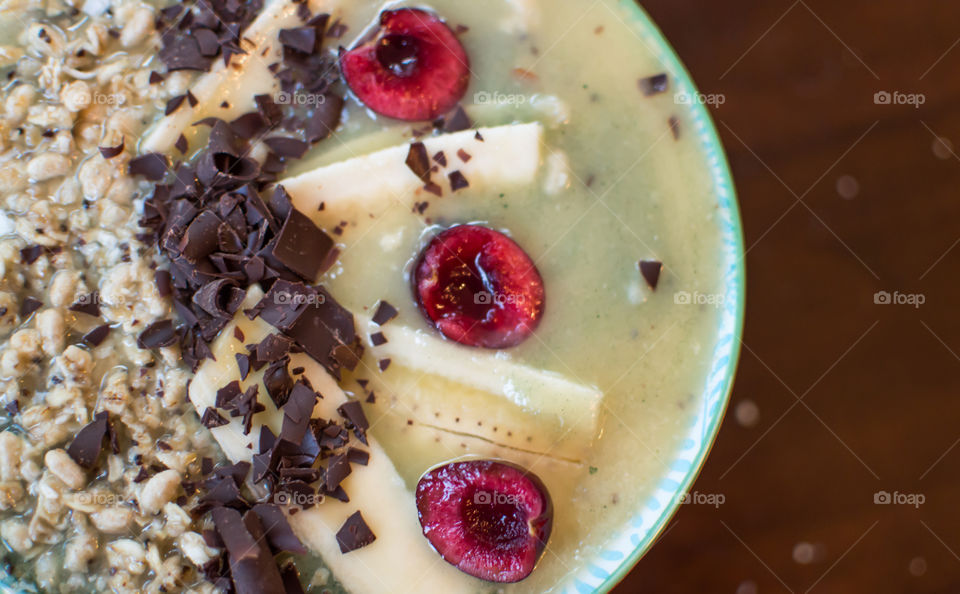 Chocolate Cherry Banana Fruit Smoothie with coconut and granola in bowl beautiful sweet artisanal smoothie background photography 