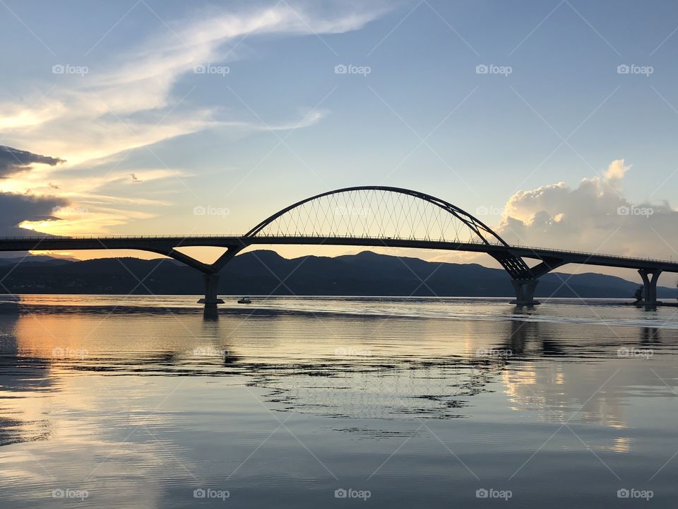 pretty sunset behind a tall bridge 