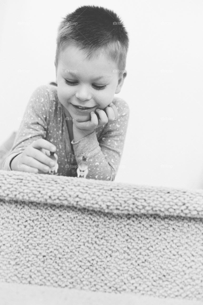 5 year old boy playing with plastic animals 