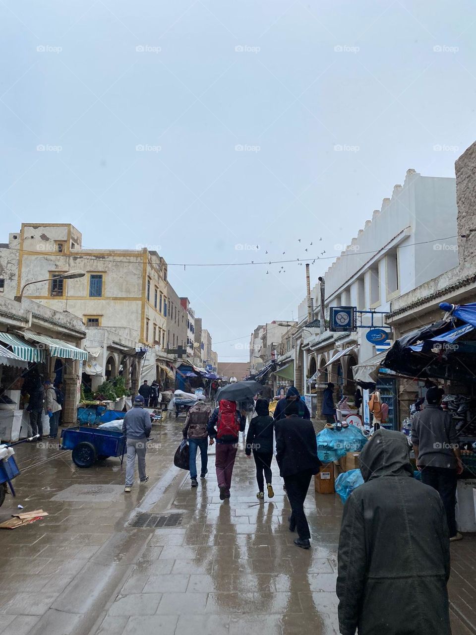 People walking in the street af essaouira city in Morocco in a rainy day.