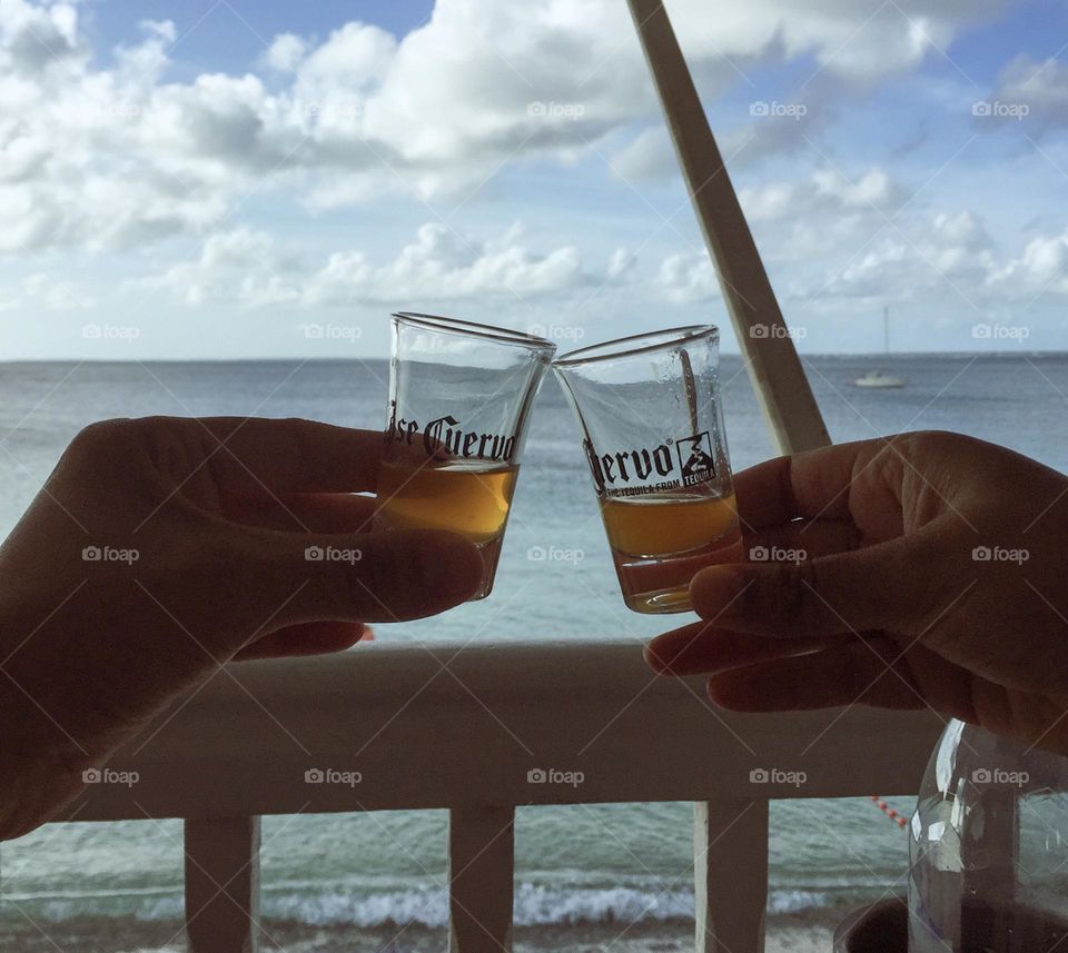 Two women having drinks by the sea, cheers by the seaside, celebrating by the seashore, celebrating successful semester 