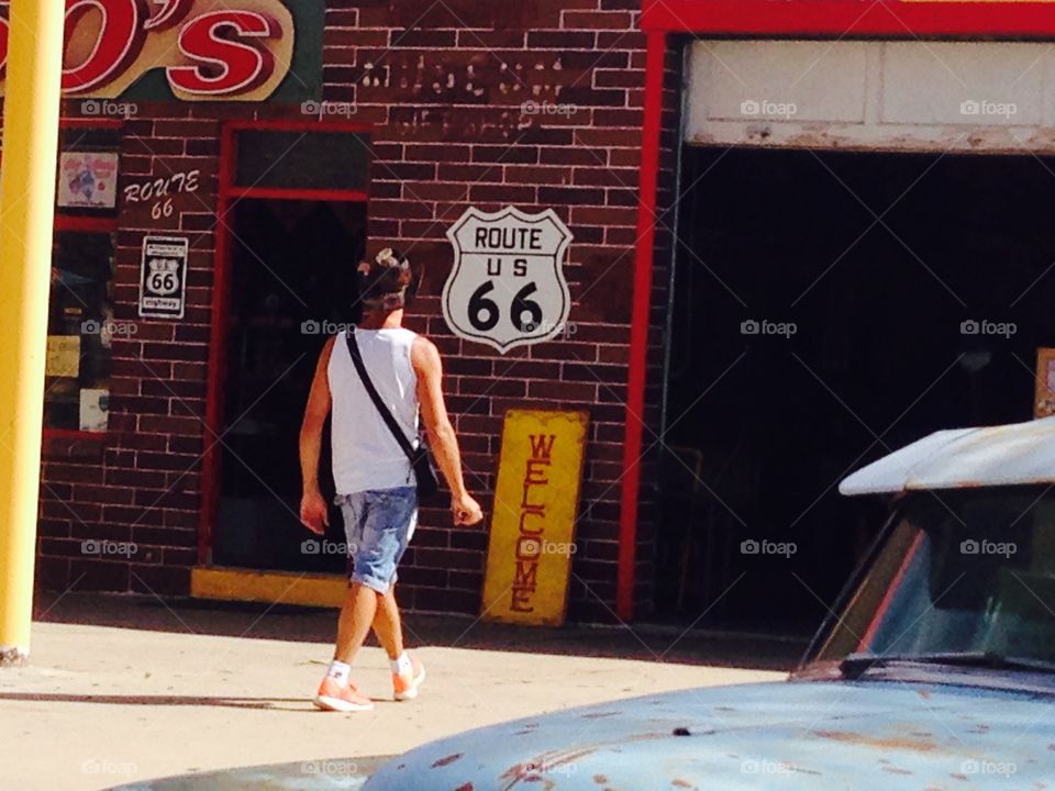 Man in front of route66 sign 