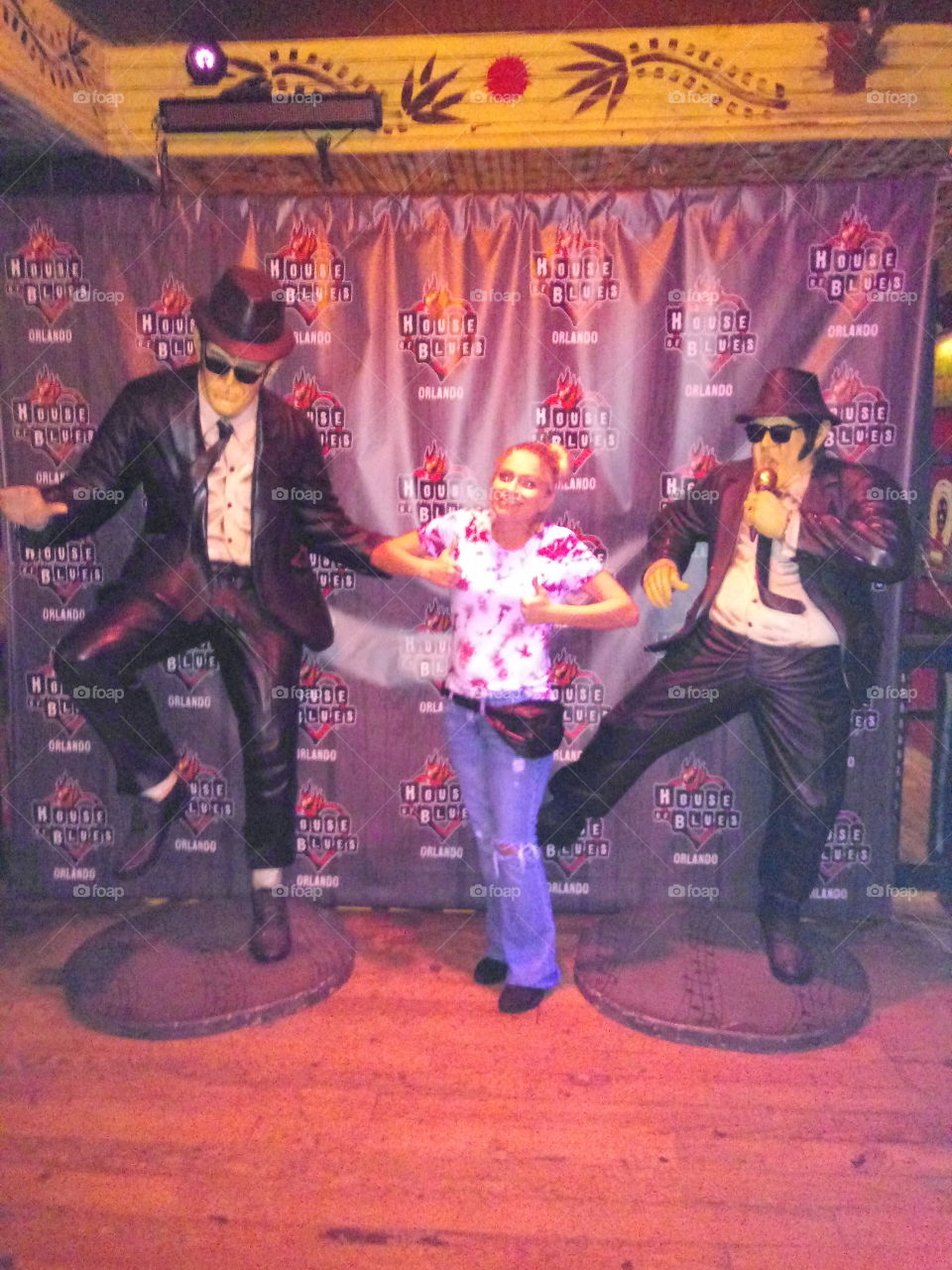 young woman posing with statues at the house of blues in orlando, Florida