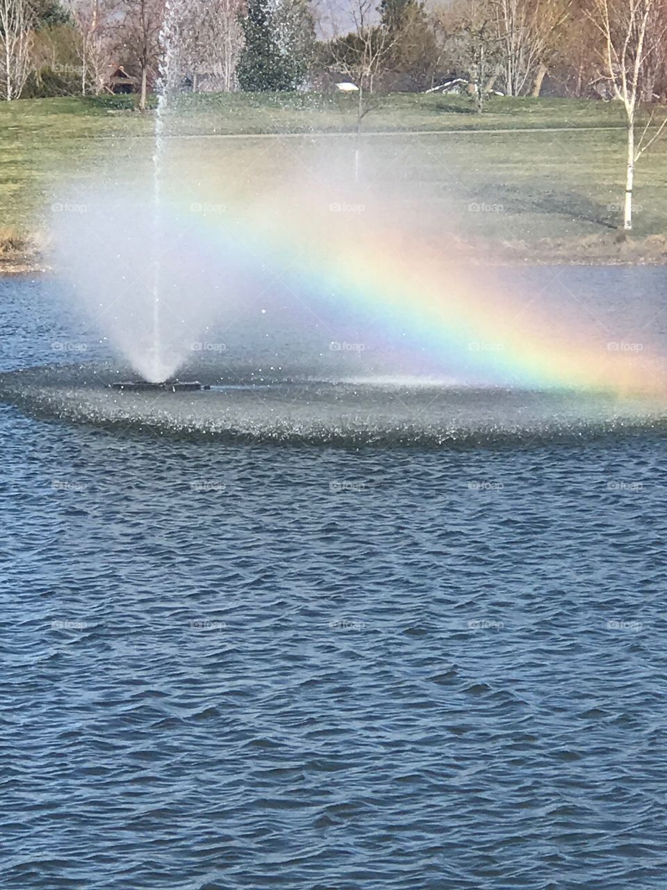 Photo taken at a local park. The light reflected from the water made this stunning rainbow. 