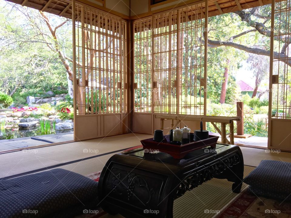 The interior of a traditional Japanese teahouse in Southern California. Open sliding screens provide a view of the surrounding garden. Storrier Stearns Japanese Garden, Pasadena, California.