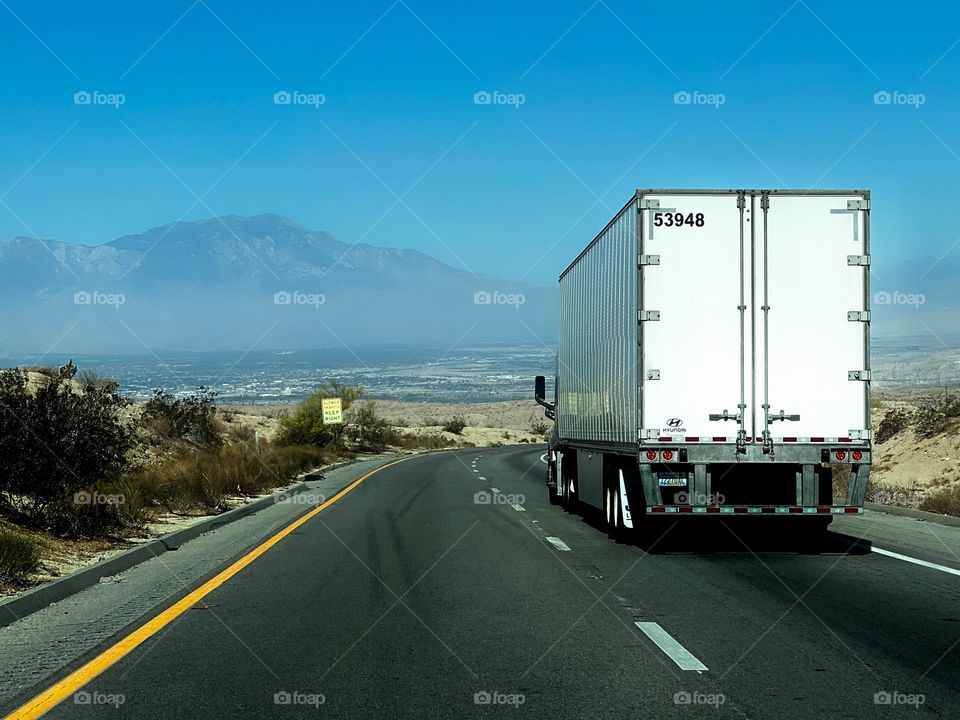 View of Coachella California driving on Interstate 10 highway through Thermal California with a semi truck in front of me 