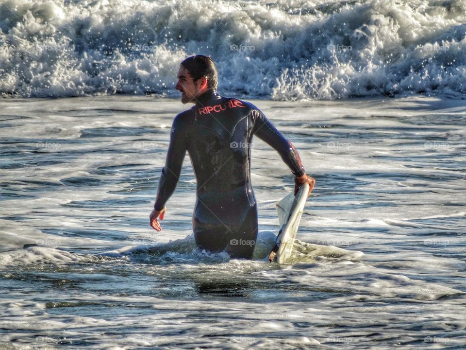 Athletic Surfer Enters The Ocean. California Surfer
