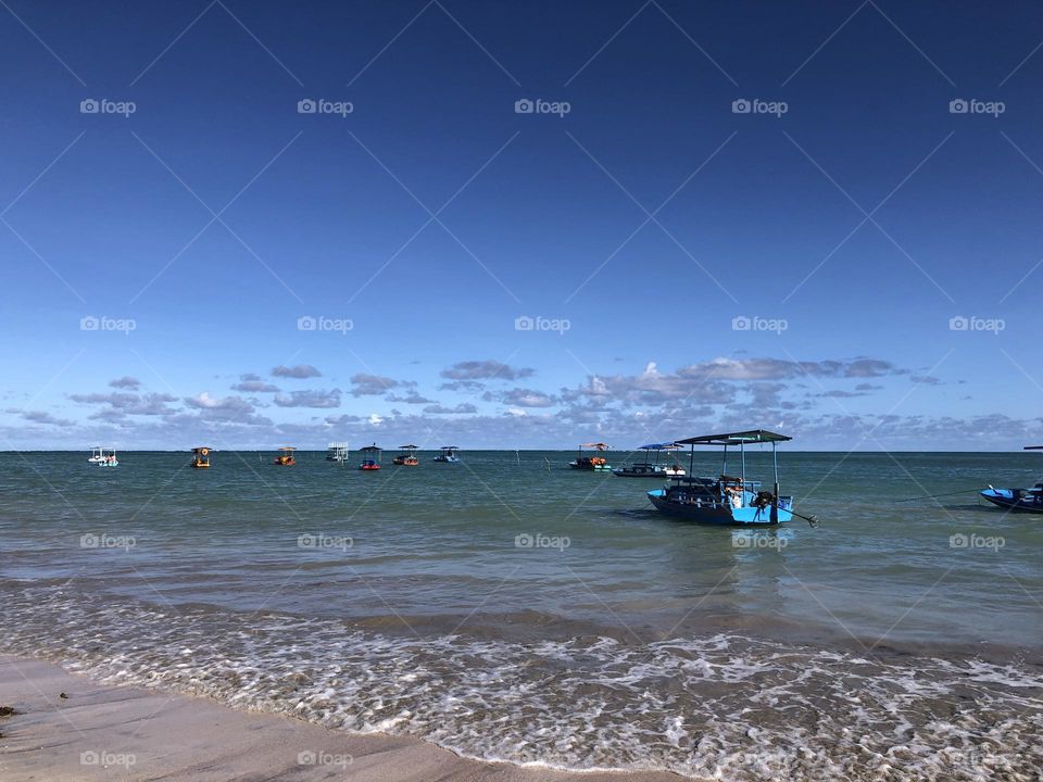 Colorful boats at the beach in a blue sky