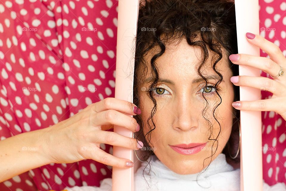 Portrait of a woman brunette on pink background