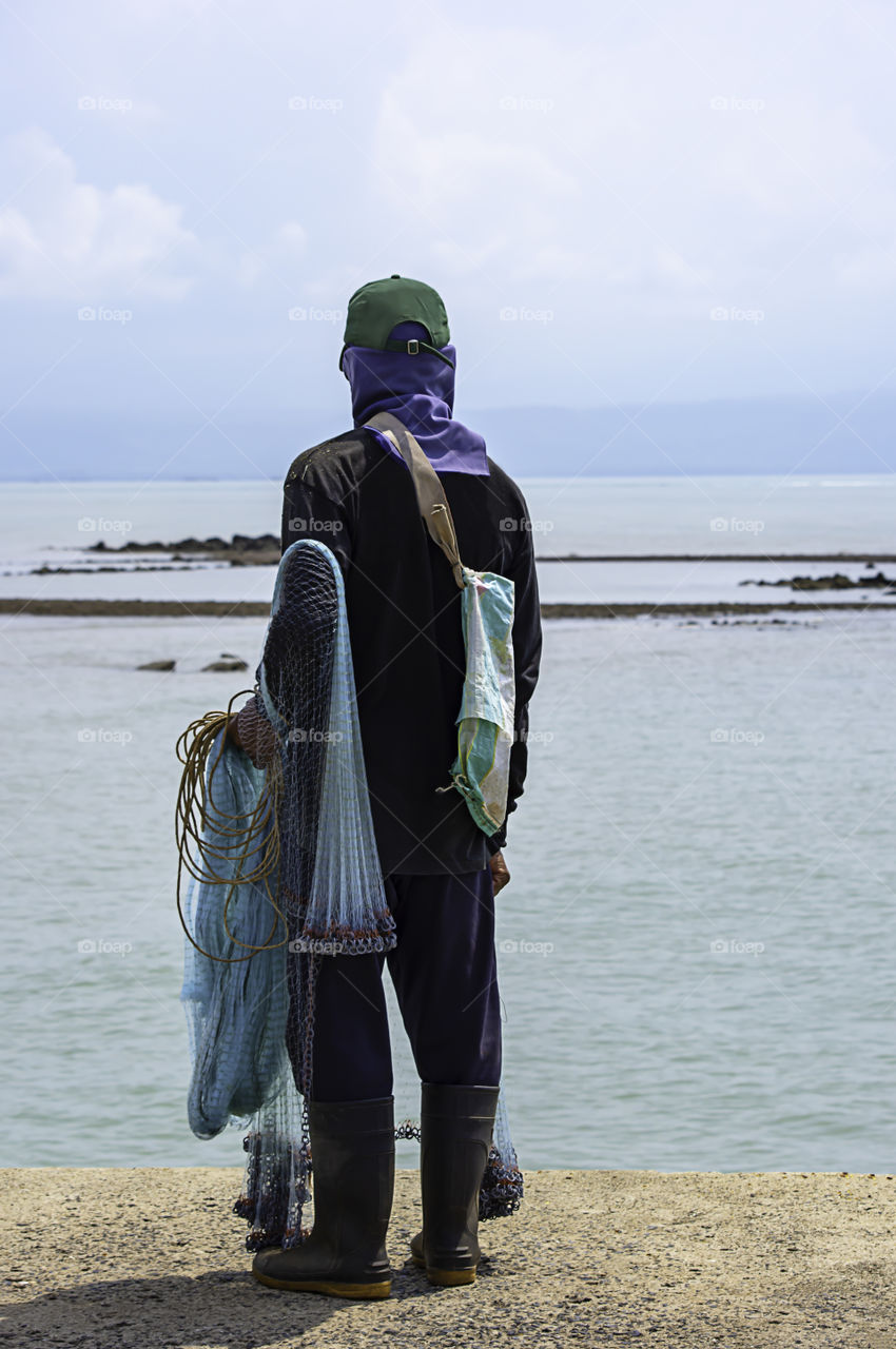 Man holding fishing nets Background sea and sky.