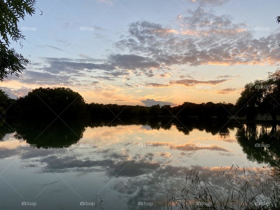 Orange clouds reflecting in the lake at sunset 
