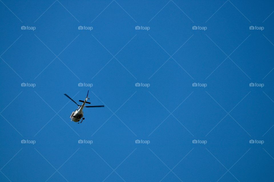 Helicopter in vivid blue sky, minimalism, desktop and room for copy or text 