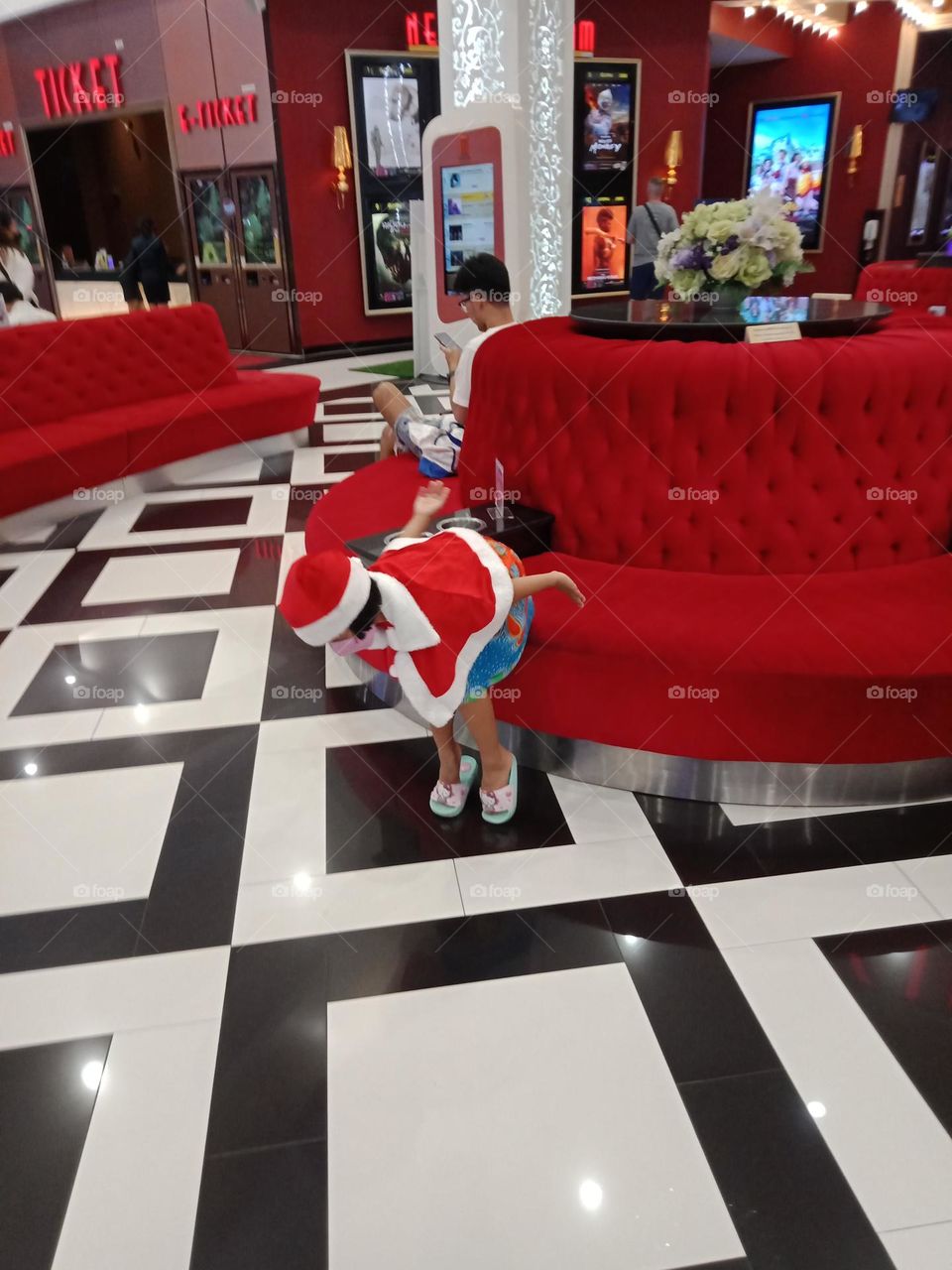 Kid in red at round shape red sofa