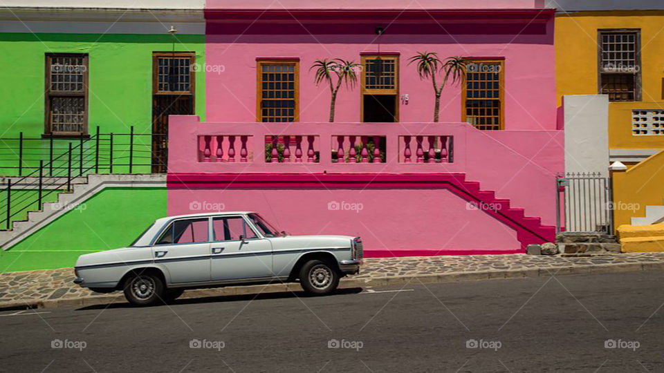 Mercedes front of colorful house 