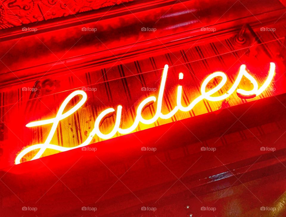 Neon ladies sign for bathroom at a bar