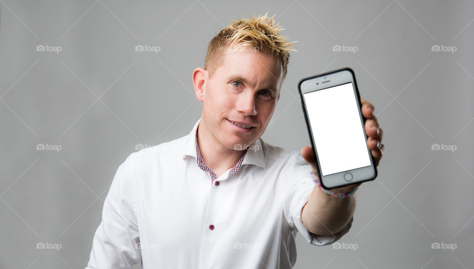 Happy man with cellular phone smiling and showing his phone.