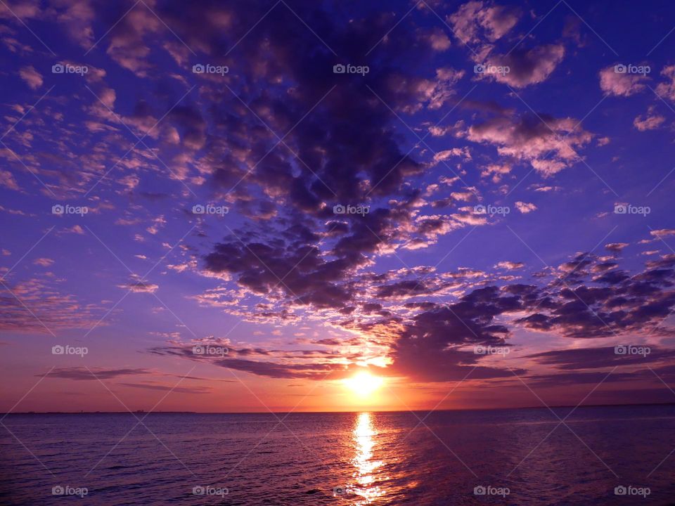 Color Purple - a magnificent mauve colored sunset reflecting off the rolling waves of the bay.  Purple pillow clouds dot the sky