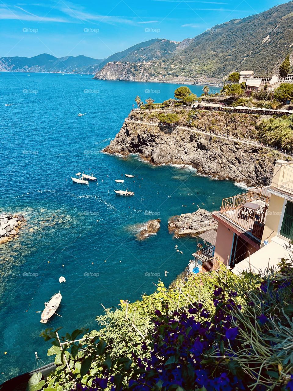 Beautiful, blue waters hugged by a mountainside on a vibrant, summer day