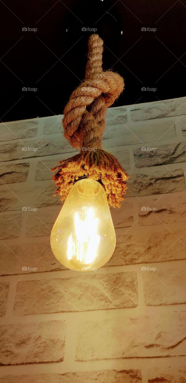 A bulb tied with a thick rope along with the beautiful brick wall texture is adding to the look of the cafe.