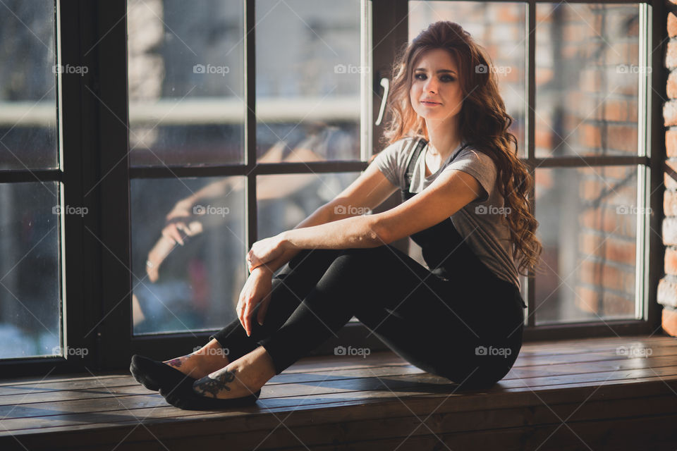 Portrait of young beautiful woman near window