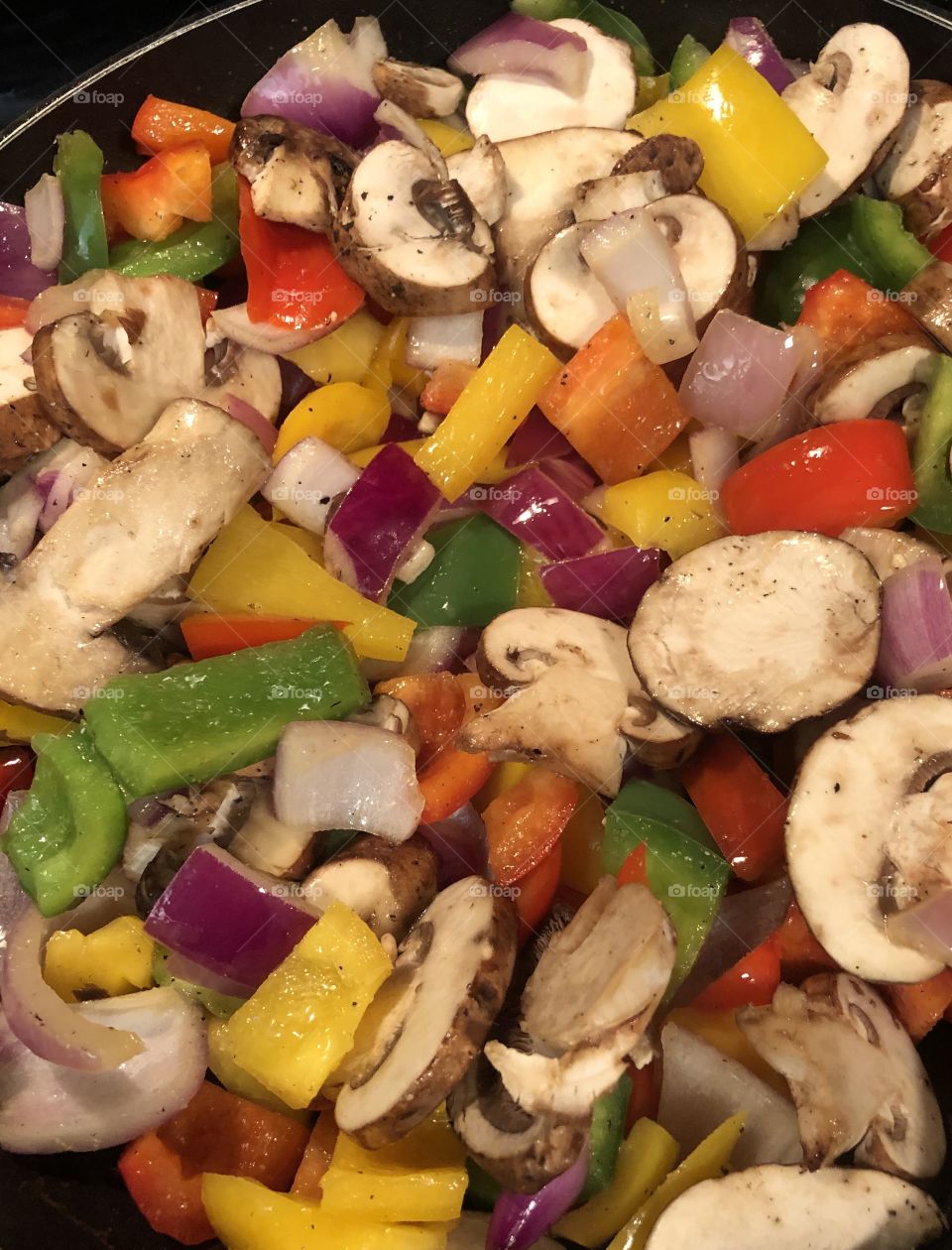 Sautéing vegetables red , yellow & green bell peppers, mushrooms & red onions 
