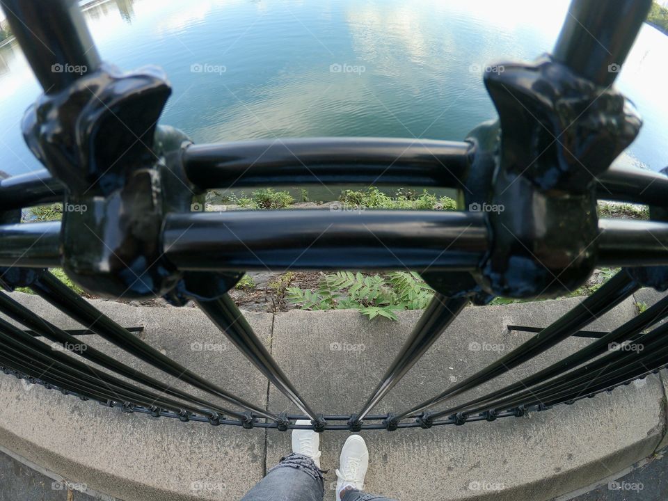 A woman white shoes stepping at the edge at Jacqueline reservoir New York.