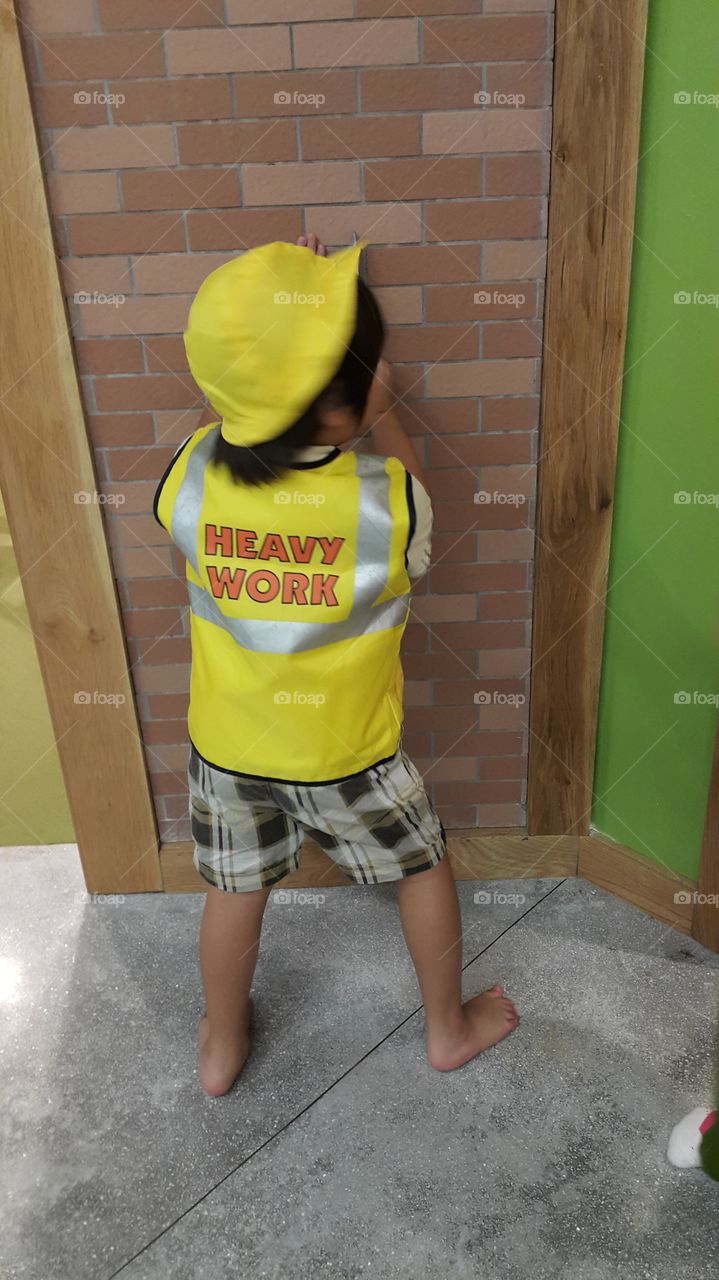 Heavy work kid. kid playing construction worker