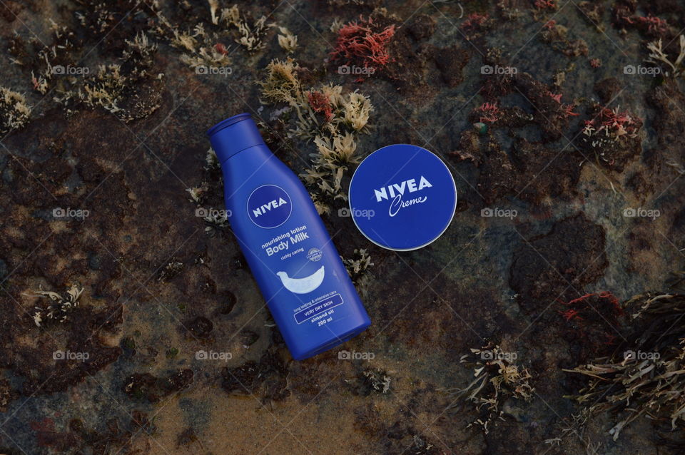 Nivea creme and body lotion are flaunted on the sea rock covered by very beautiful Marine macro algae or sea weeds.